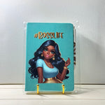 Notebook with '#BOSSLIFE' design on a clear stand against a light background