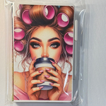Notebook with a colorful design of a woman with curlers and a coffee cup, wrapped in clear plastic.