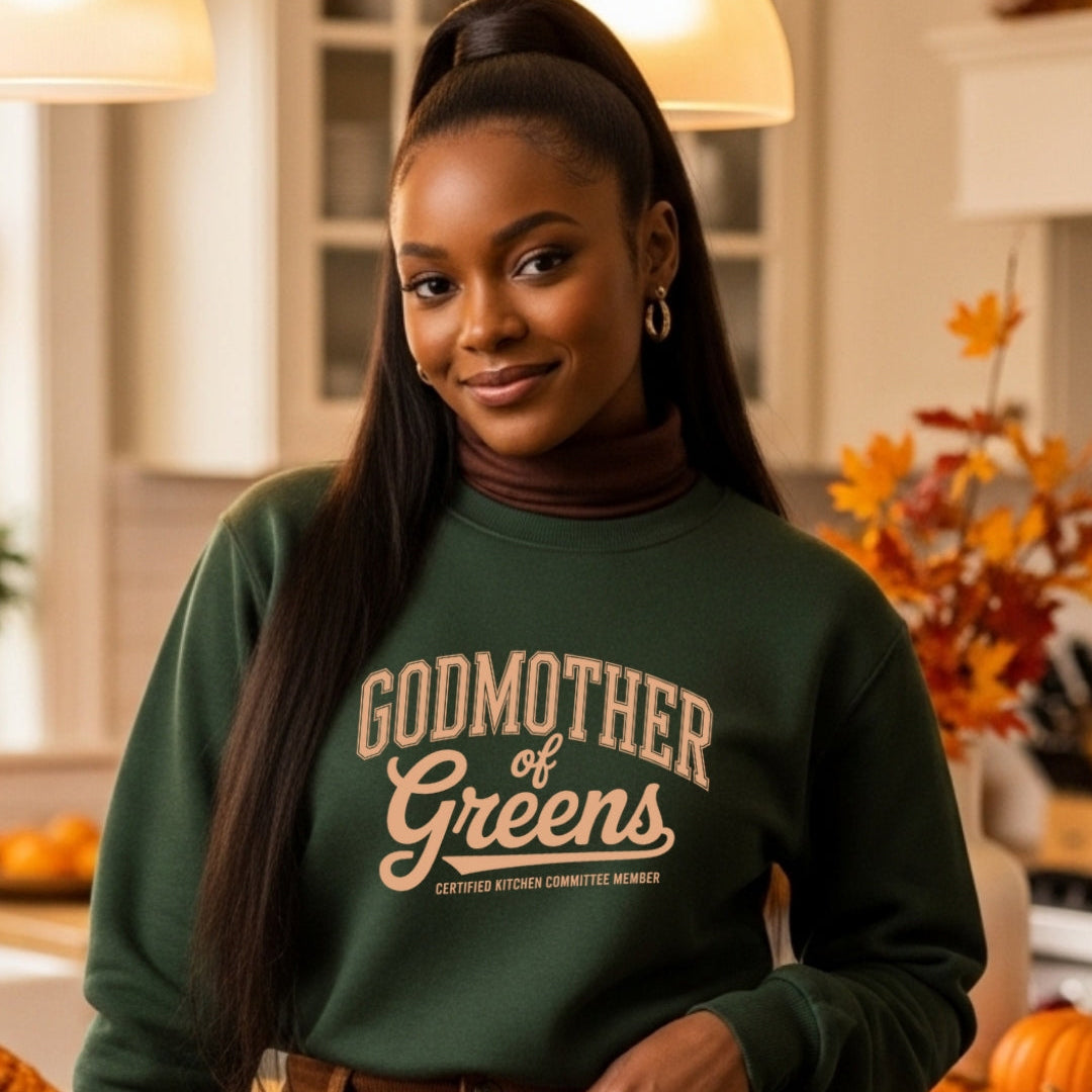 Woman wearing a green sweatshirt with 'Godmother of Greens' text in a kitchen setting with pumpkins.