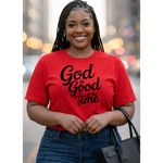 Woman wearing a red t-shirt with 'God is Good all the Time' text, standing outdoors with blurred lights in the background.
