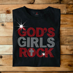 Black t-shirt with 'God's Girls Rock' text on a wooden surface