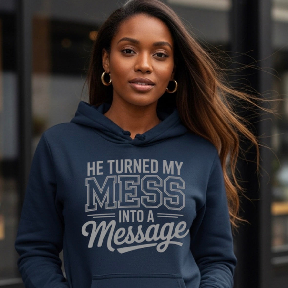 Woman wearing a navy hoodie with text, standing outdoors.