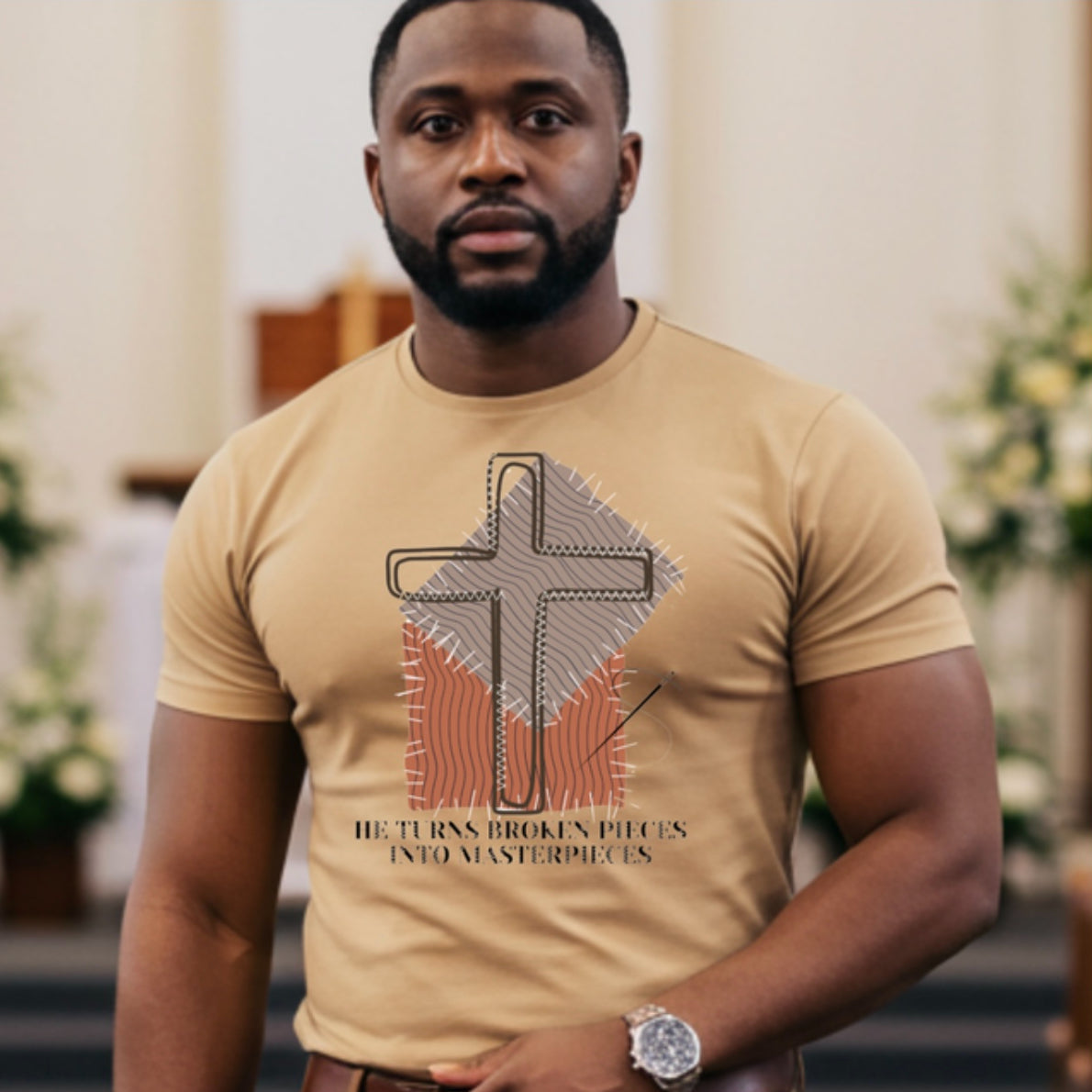 Man wearing a beige t-shirt "HE TURNS BROKEN PIECES INTO MASTERPIECES" with a cross design in a church setting