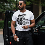 Man in a white t-shirt with a lion graphic and MAN OF GOD TSHIRT standing next to a car.