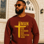 Man wearing a maroon sweatshirt with yellow text in front of a church.