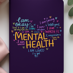 Purple notebook with motivational text on a white surface with green leaves