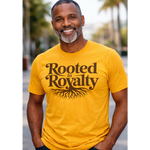 Man wearing a yellow t-shirt with 'Rooted in Royalty' text and tree graphic.