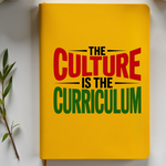 Yellow notebook with 'The Culture is the Curriculum' text, surrounded by two coffee cups on a white surface.