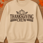 Beige sweatshirt with 'Thanksgiving Crew' text on a wooden background with fall leaves and pumpkins.