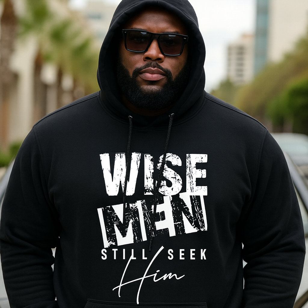 Man wearing a black hoodie with 'WISE MEN STILL SEEK HIM' text outdoors.
