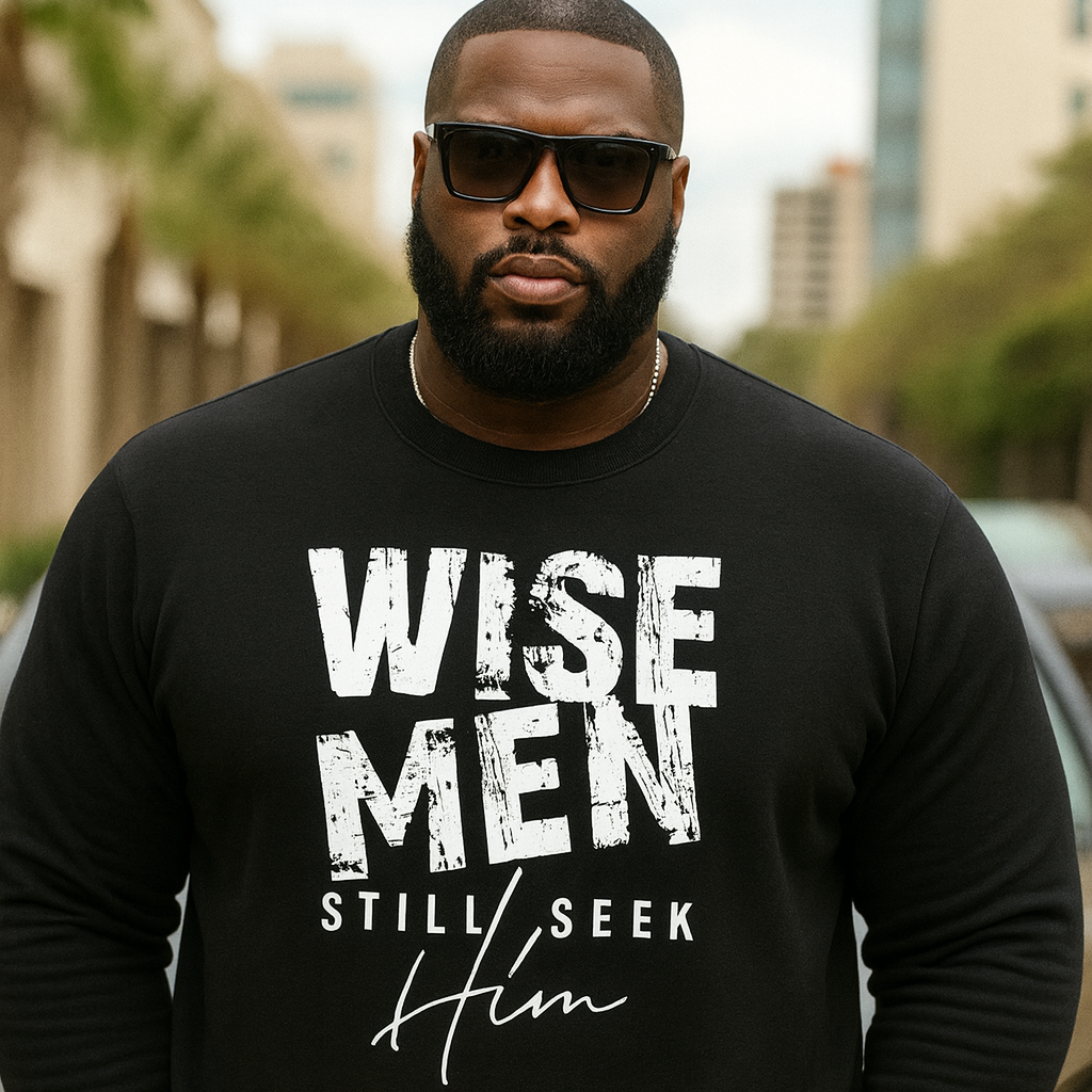 Man wearing a black sweatshirt with 'WISE MEN STILL SEEK HIM' text, standing outdoors.