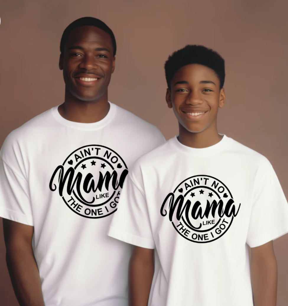 Two individuals, one adult and one child, wearing white crew neck t-shirts with the text 'AIN'T NO MAMA LIKE THE ONE I GOT' printed on the front.