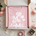 Pink t-shirt with 'Best Mom Ever' design in a box, surrounded by roses and a tag.