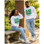 Two people wearing 'Black History Month 365' shirts sitting outdoors.