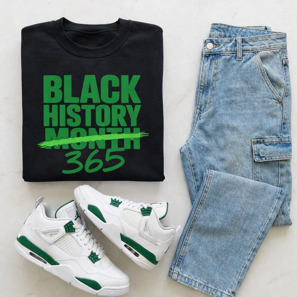 Black History Month t-shirt, white sneakers with green accents, and blue jeans on a light gray background