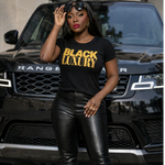 Person wearing a black t-shirt with 'BLACK LUXURY' text in front of a Range Rover.