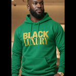 Person wearing a green hoodie with 'BLACK LUXURY' text, standing indoors.