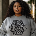 Person wearing a gray sweatshirt with 'blessed' mandala design.
