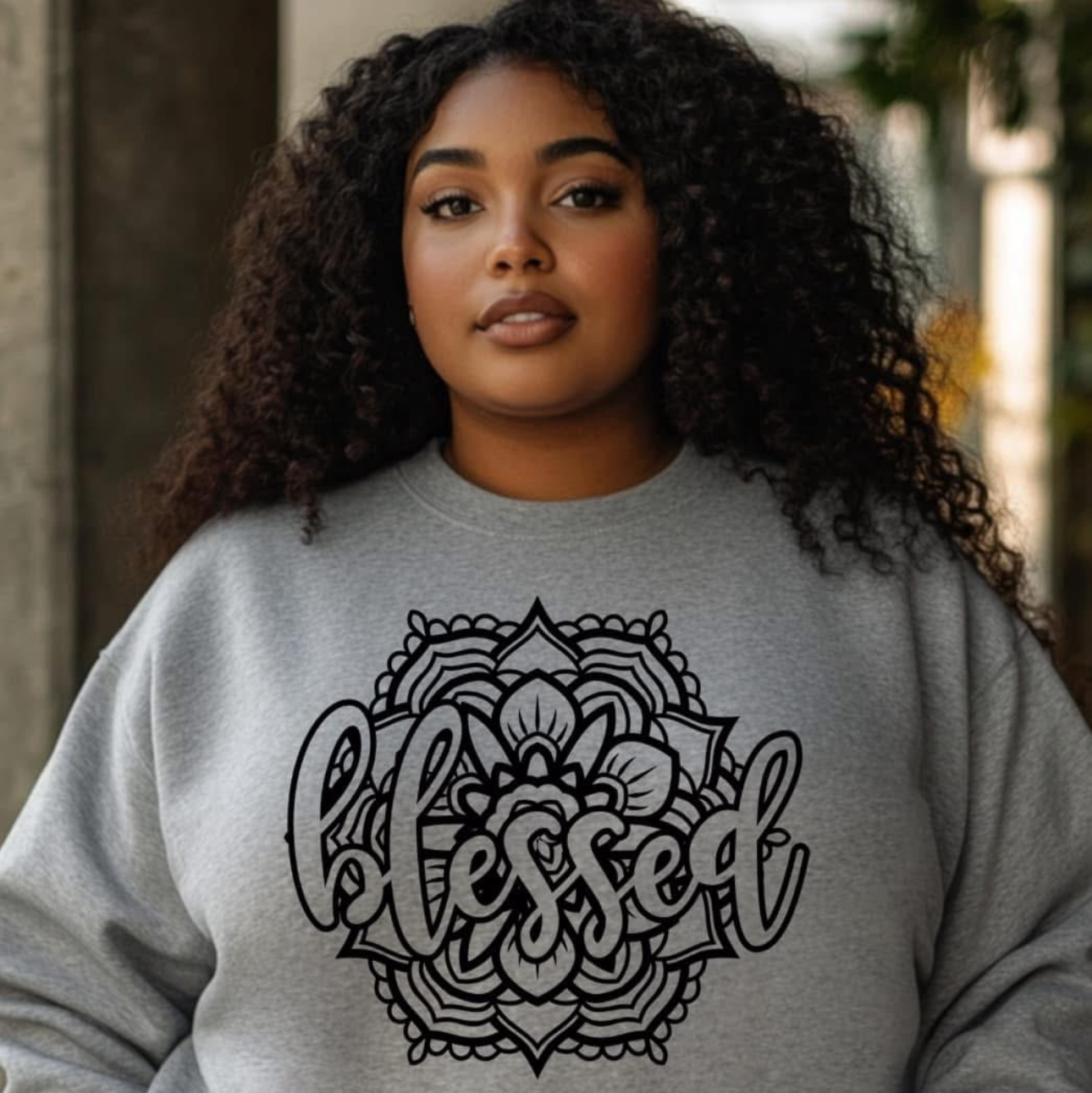 Person wearing a gray sweatshirt with 'blessed' mandala design.