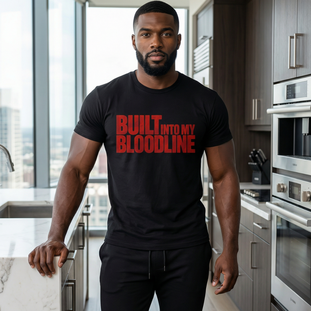 Man wearing a black t-shirt with red text in a modern kitchen