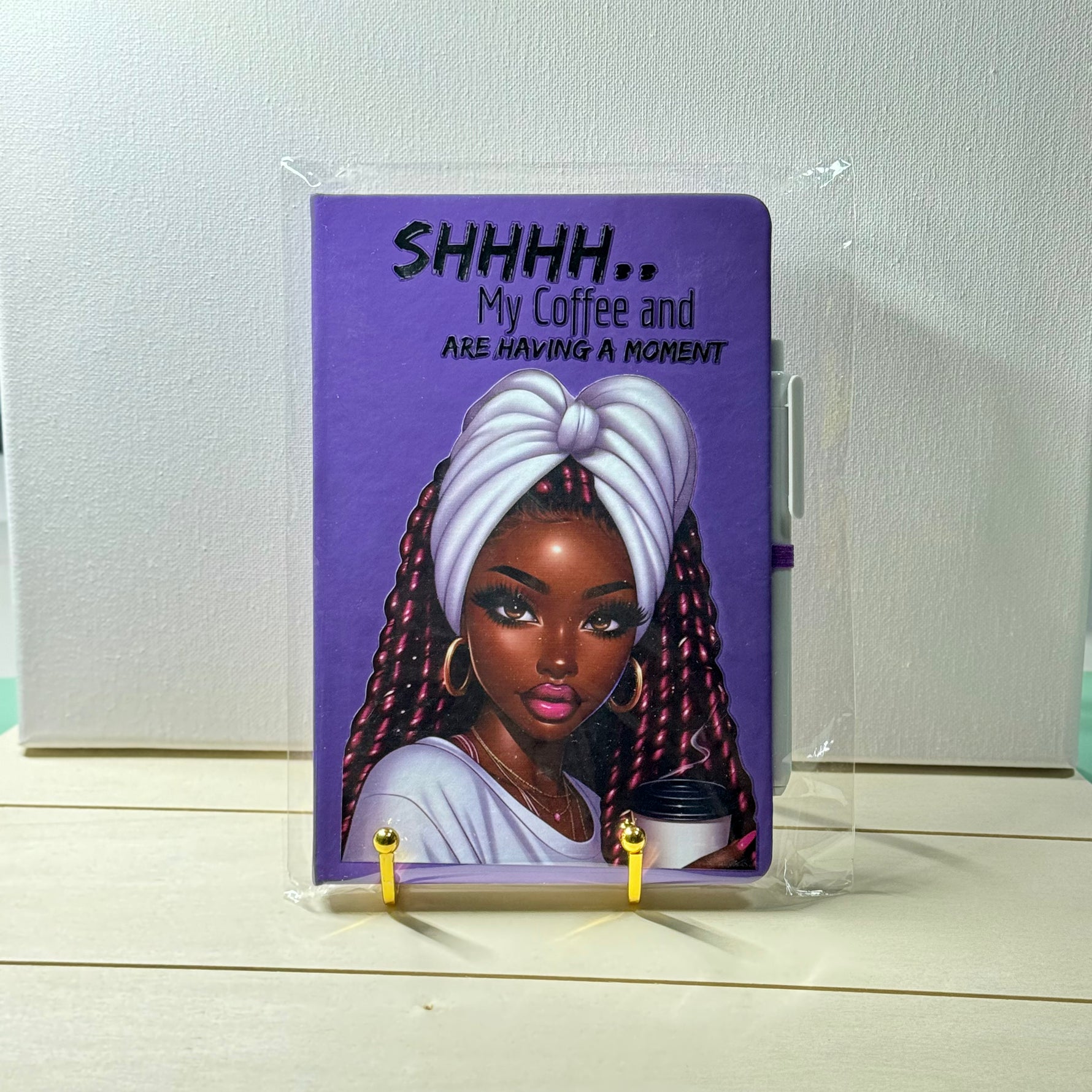 Notebook with a purple cover featuring an illustration of a woman and text, on a white background.