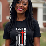 Woman wearing a black t-shirt with 'Faith Over Fear' design outdoors.