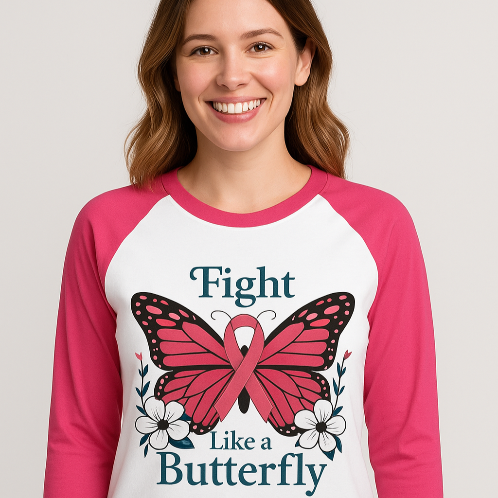 Woman wearing a pink and white baseball shirt with a butterfly and ribbon design, smiling.