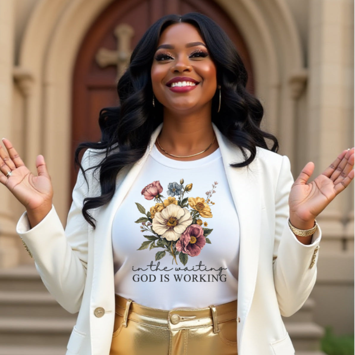 Woman wearing a white shirt with floral design and text  IN THE WAITING GOD IS WORKING