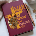 Notebook with lion design and text on a white surface with a cup of tea and pen.