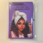 Notebook with a purple cover featuring a woman with a white turban and a coffee cup, text 'SHHHH.