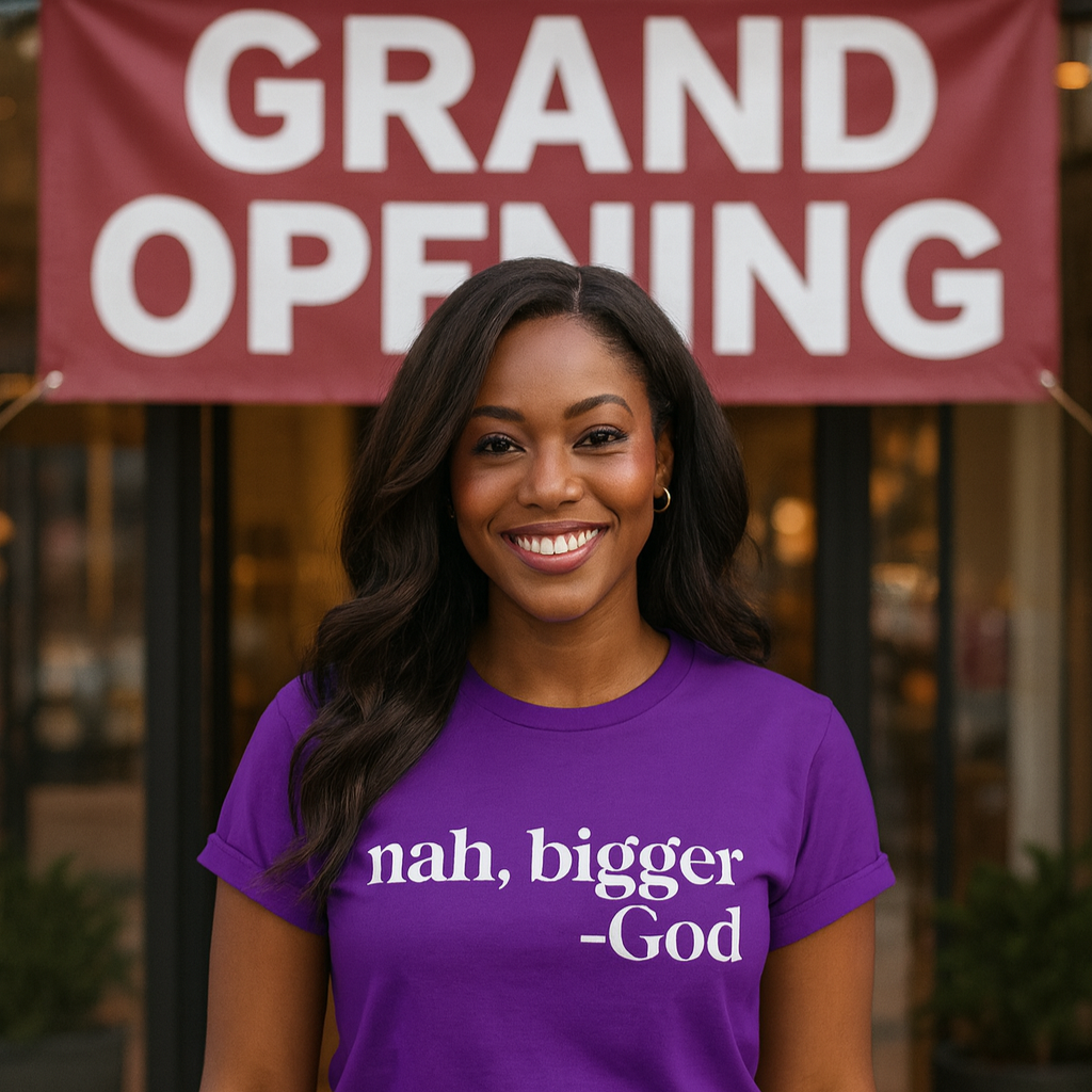 Person wearing a purple t-shirt with text, standing in front of a 'Grand Opening' sign.