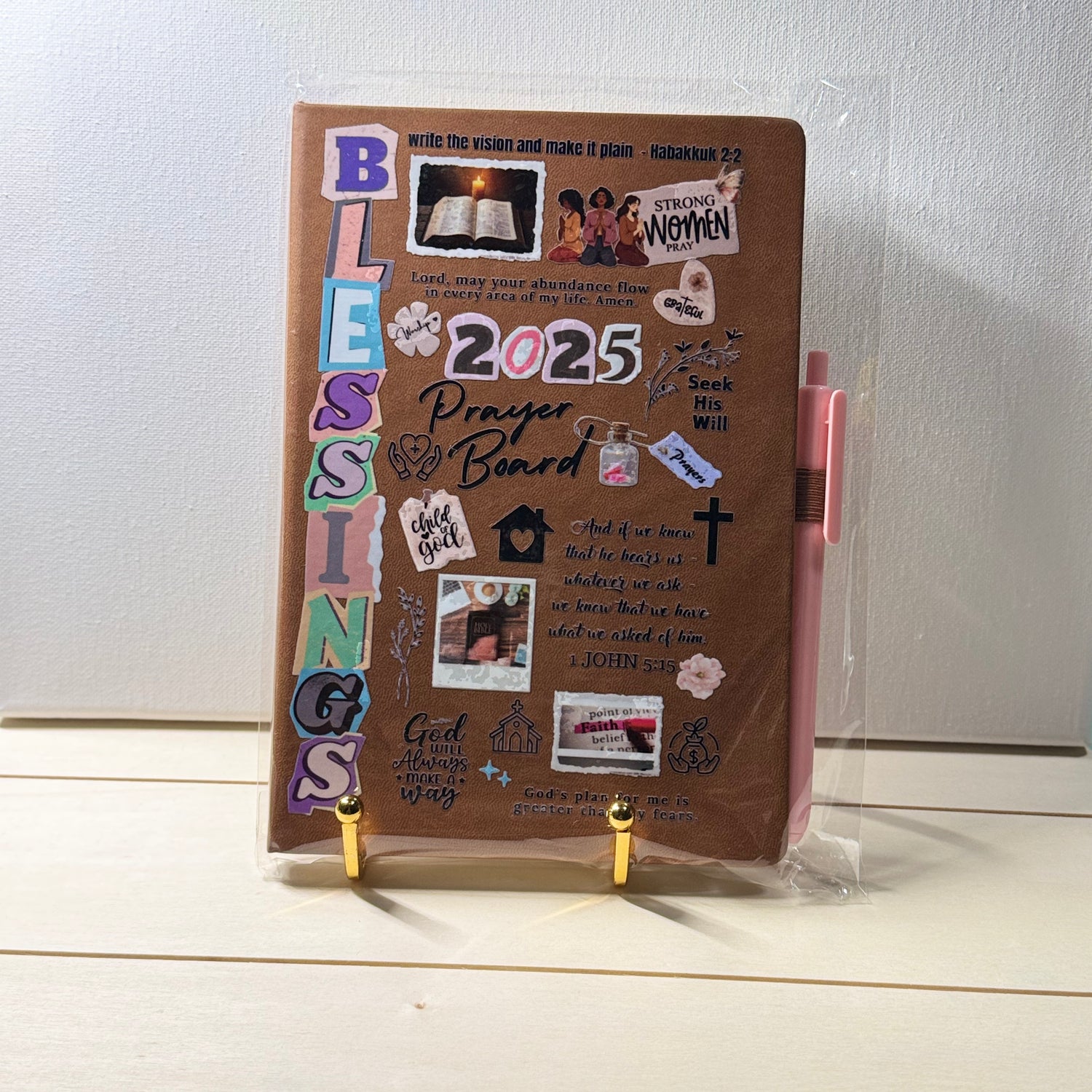 Brown prayer board with various stickers and a pen on a white surface