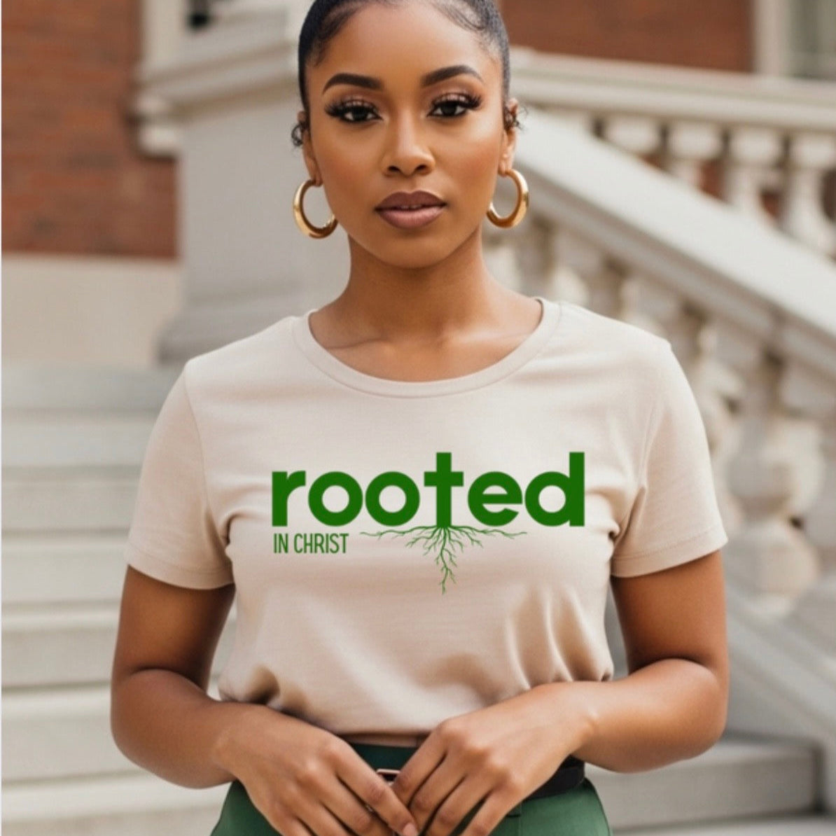 Woman wearing a 'rooted in Christ' t-shirt standing on steps.