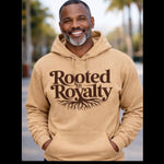 Man wearing a beige hoodie with 'Rooted in Royalty' text and tree design outdoors.