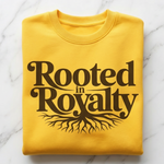 Yellow sweatshirt with 'Rooted in Royalty' text on a marble background