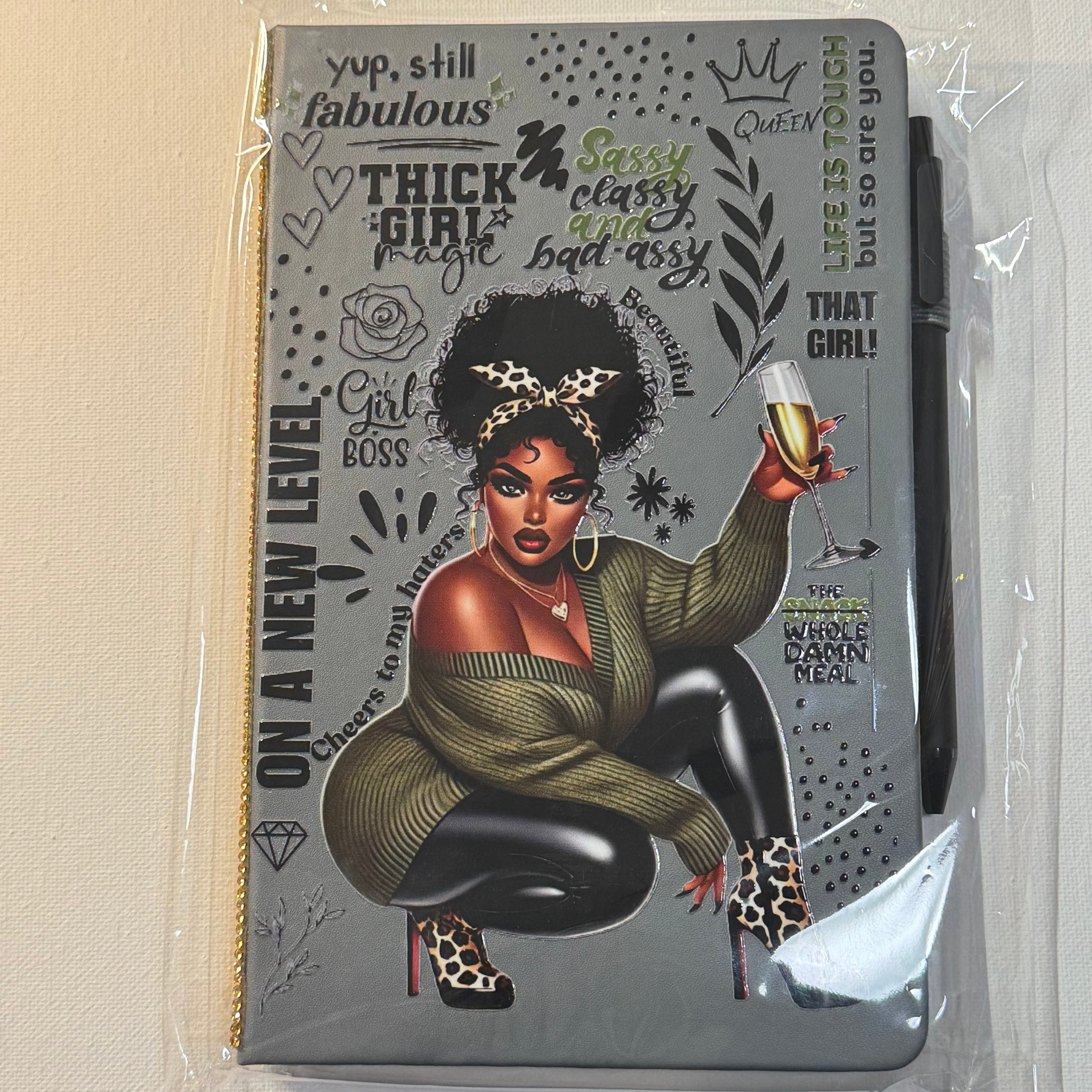 Notebook with a graphic design of a woman on the cover, surrounded by text and symbols.