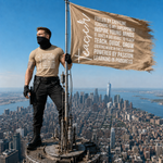 A man in a black face mask and tan graphic t-shirt stands on a rooftop antenna structure overlooking a city skyline, holding a large tan banner with motivational text.