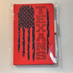 Red notebook with 'TEXANS' and American flag design in clear packaging on a white surface.