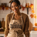 Woman wearing a 'Thanksgiving Crew' apron in a kitchen setting with fall decorations.