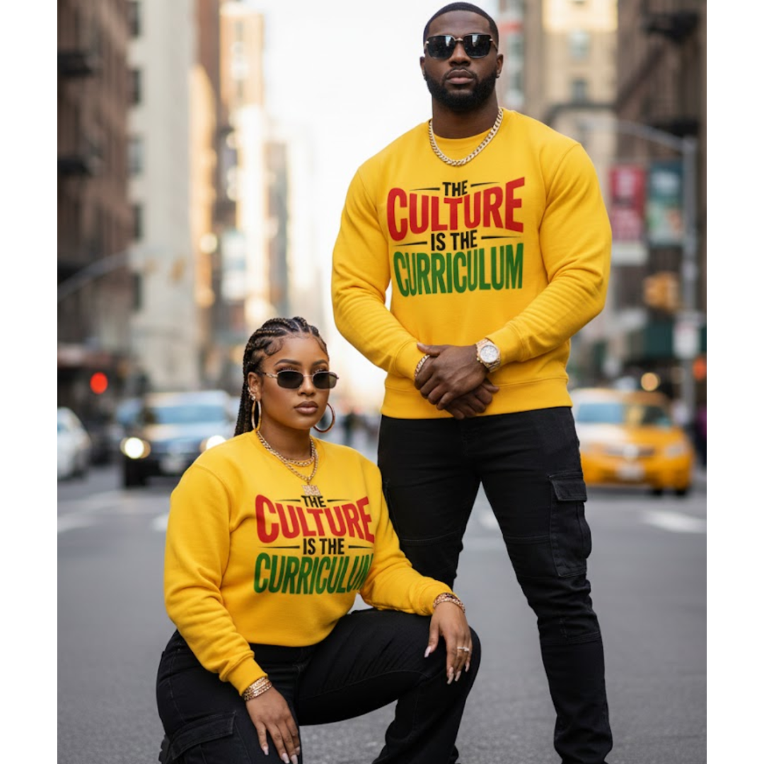 Two people wearing yellow sweatshirts with 'The Culture is the Curriculum' text on a city street.
