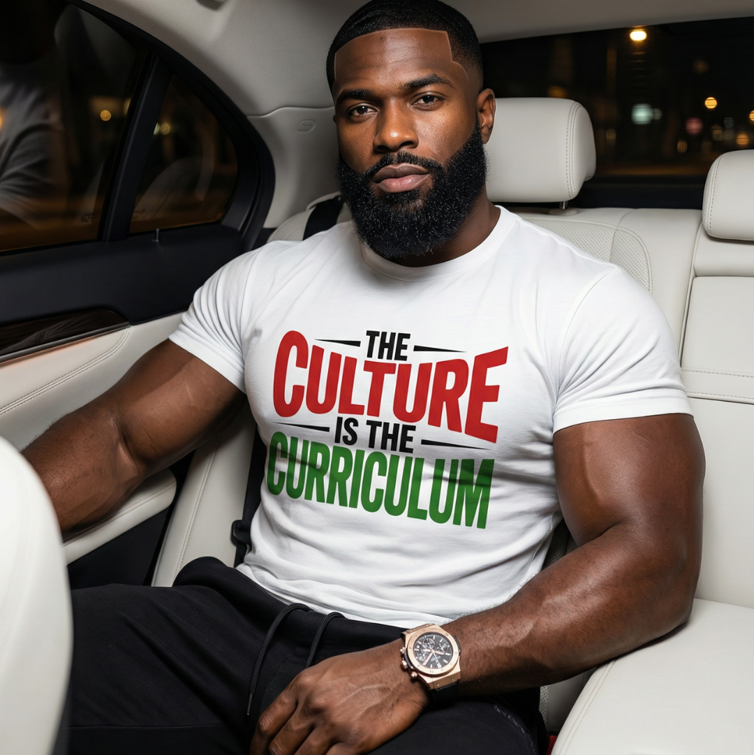 Man sitting in a car wearing a white t-shirt with a message.