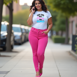 Woman in pink pants and a white t-shirt with colorful text "THIS GIRL WILL CHANGE THE WORLD" on a sidewalk.