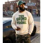 Man wearing a white sweatshirt with green text standing on a street.
