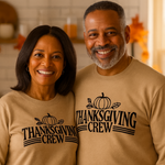 Two people wearing 'Thanksgiving Crew' sweaters with a turkey and pumpkin in front of them.