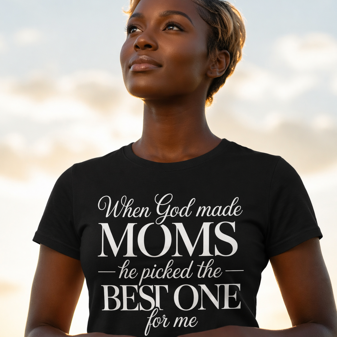 Woman wearing a black t-shirt with a motivational quote against a blurred natural background