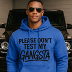 Man wearing a blue hoodie with text in front of a black SUV.